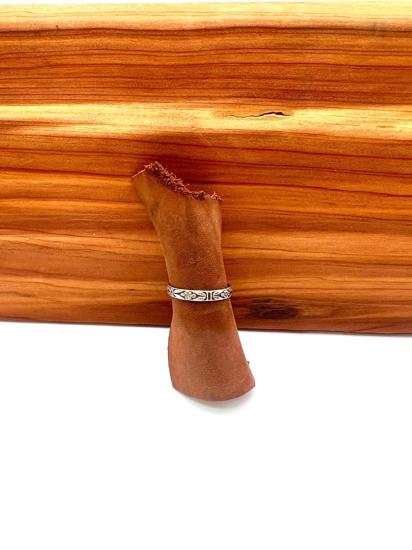 delicate sterling ring with floral details on a wooden background