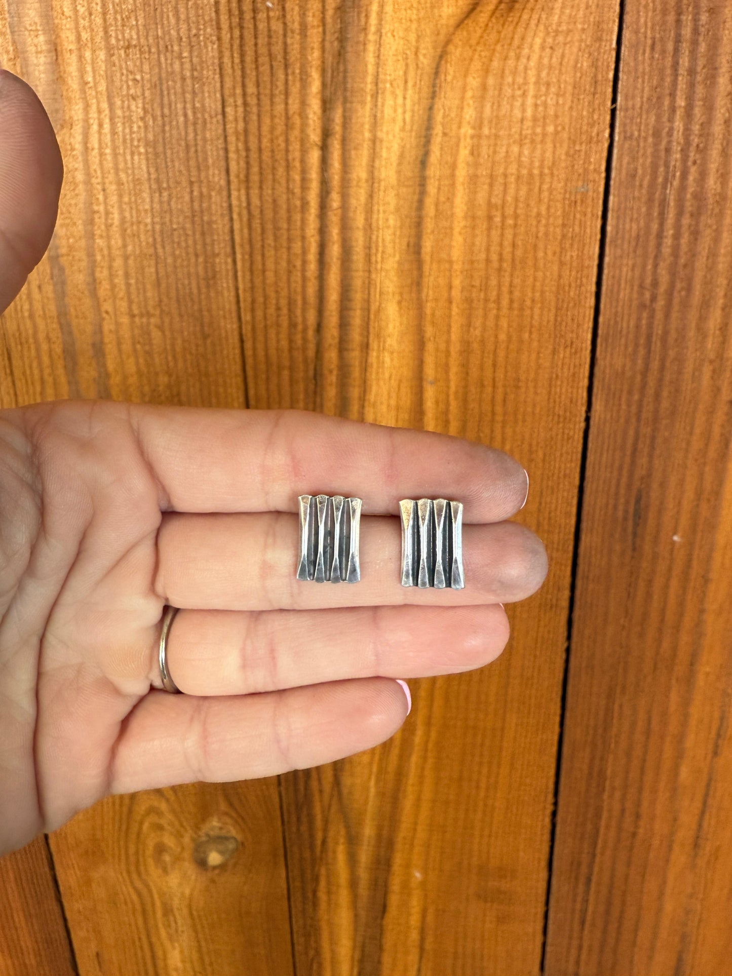 sterling silver earrings with oxidized accents on a wooden background
