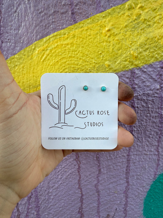 small turquoise earrings against a colorful background