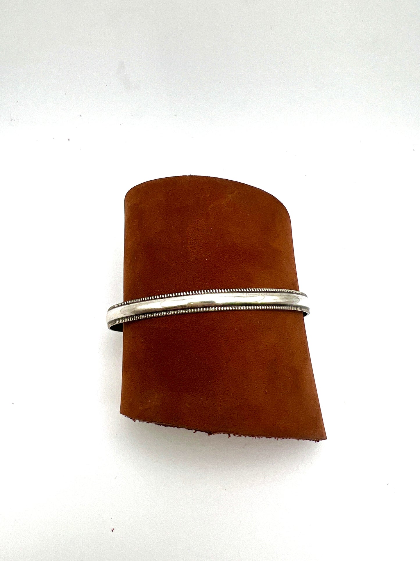 silver cuff bracelet on a leather roll