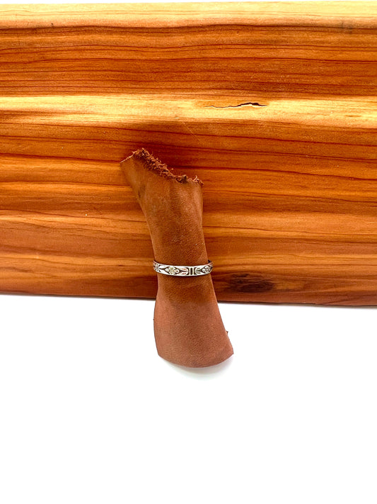 delicate sterling ring with floral details on a wooden background